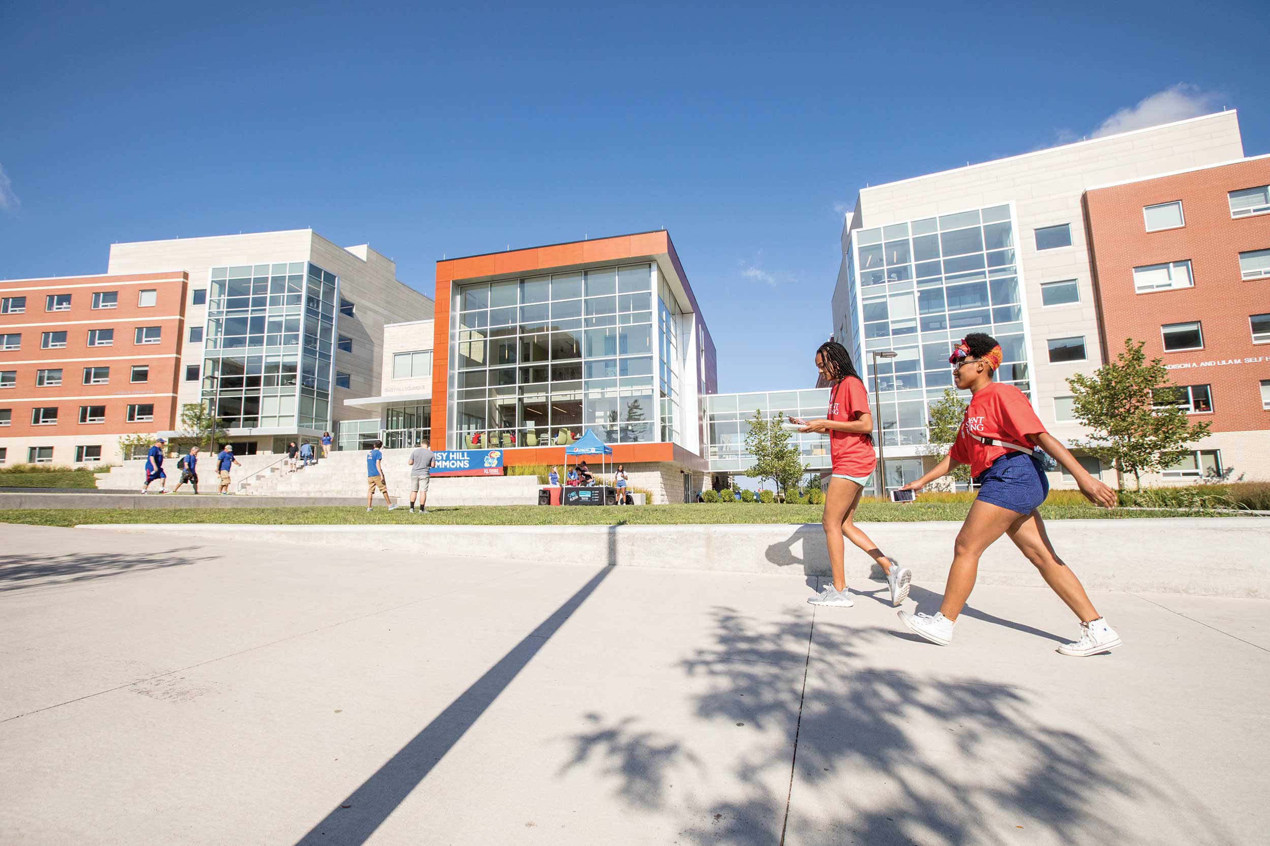 Two students walking in front of Daisy Hill Commons