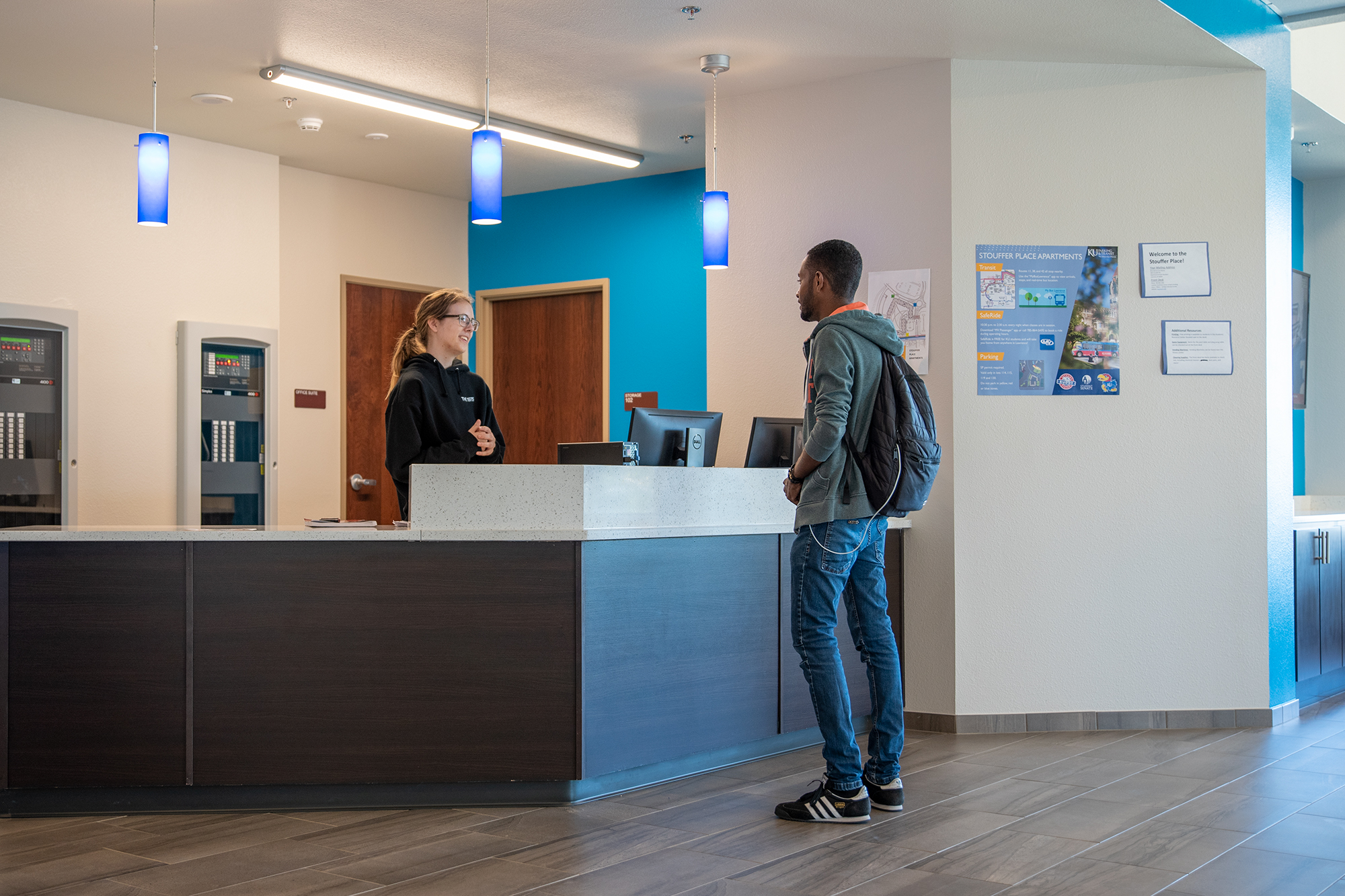 a student speaking with the front desk assistant in their hall