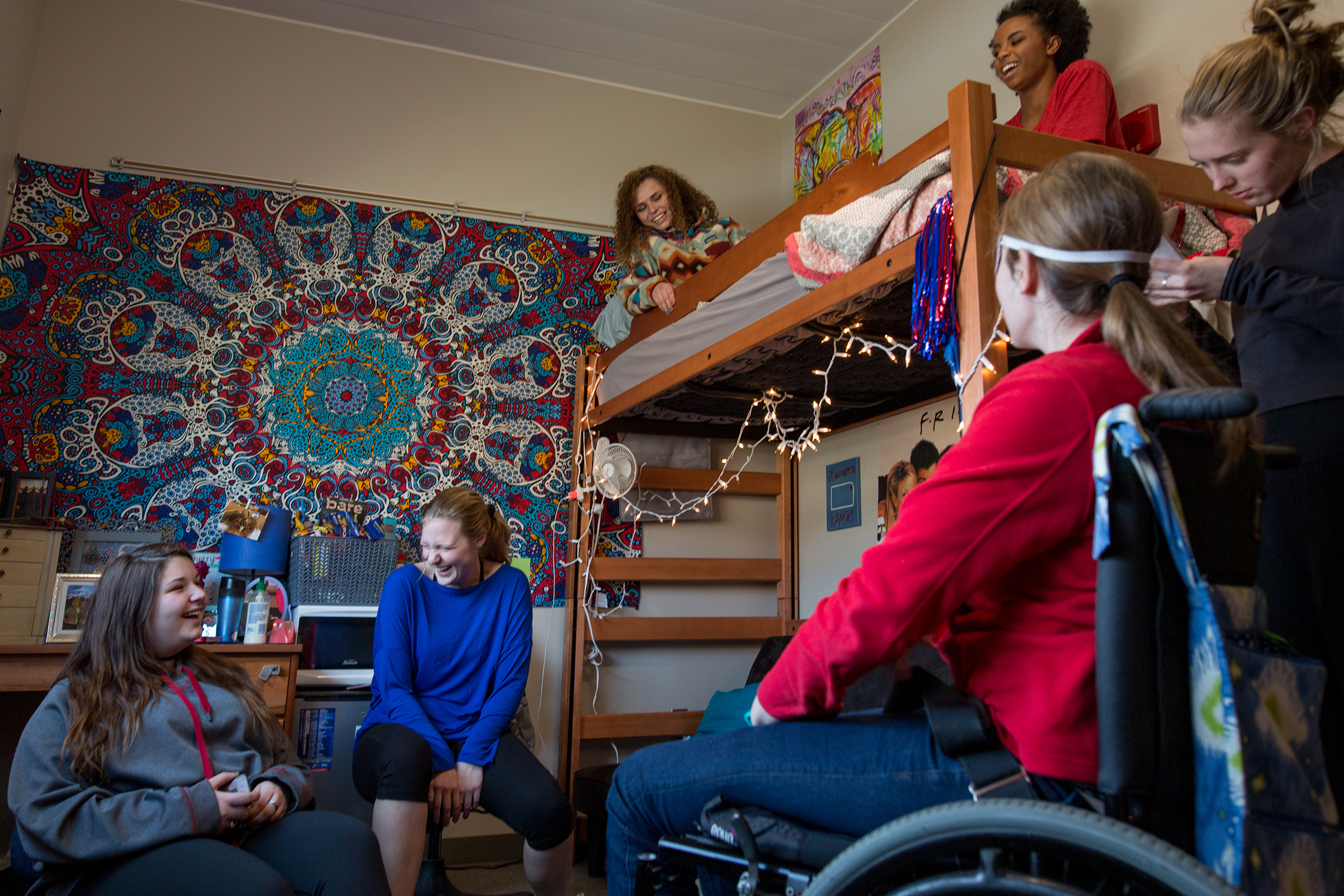 a student in a wheelchair hanging out with friends in their room