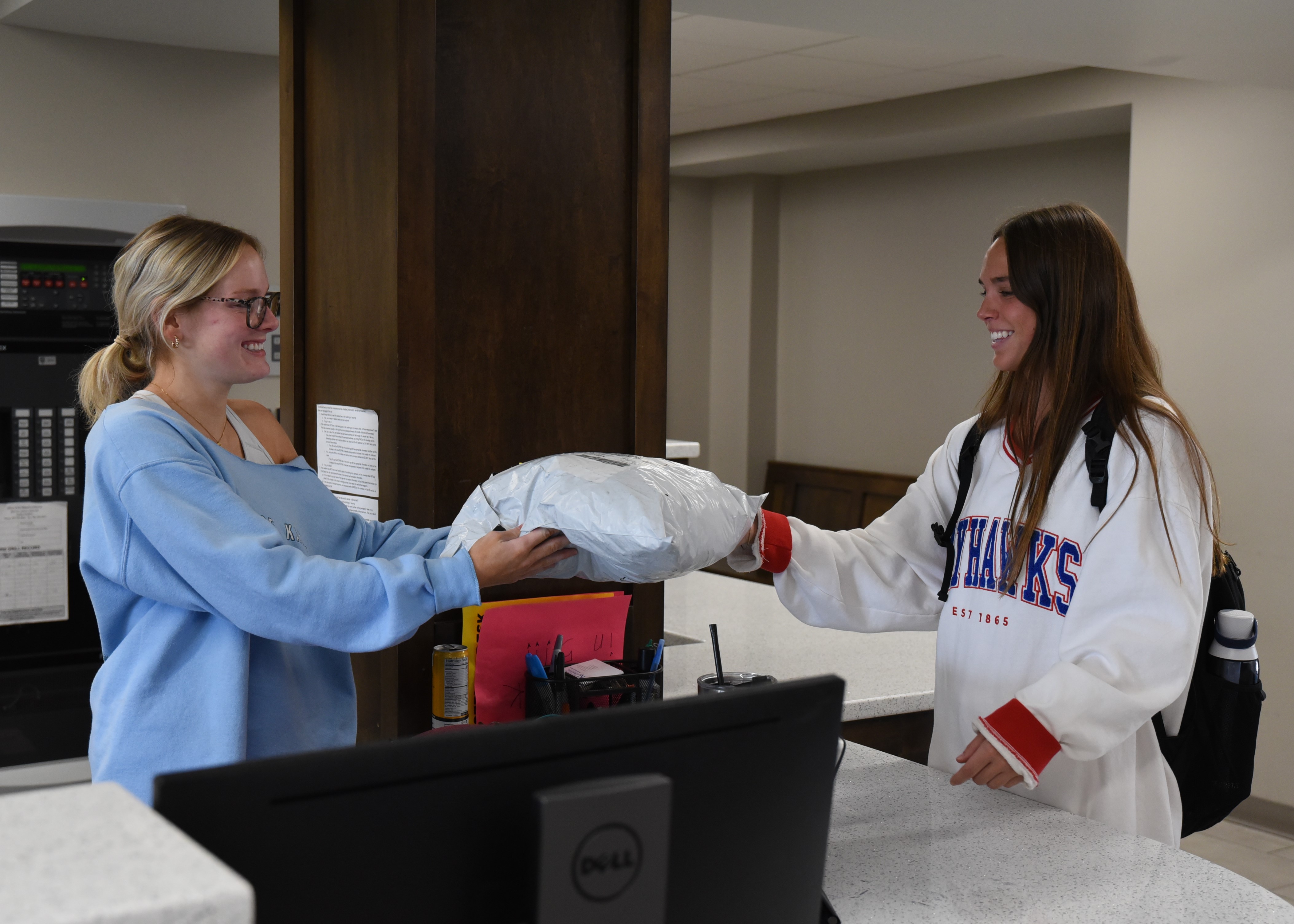 Desk assistant handing a student a small package