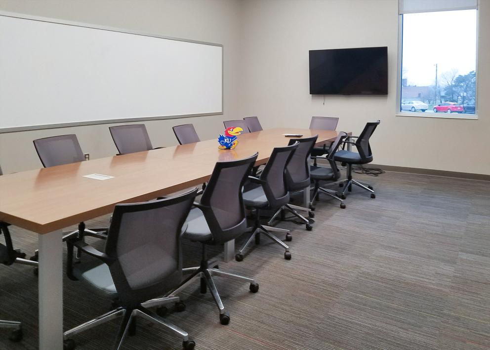conference room with long table, white board, and TV