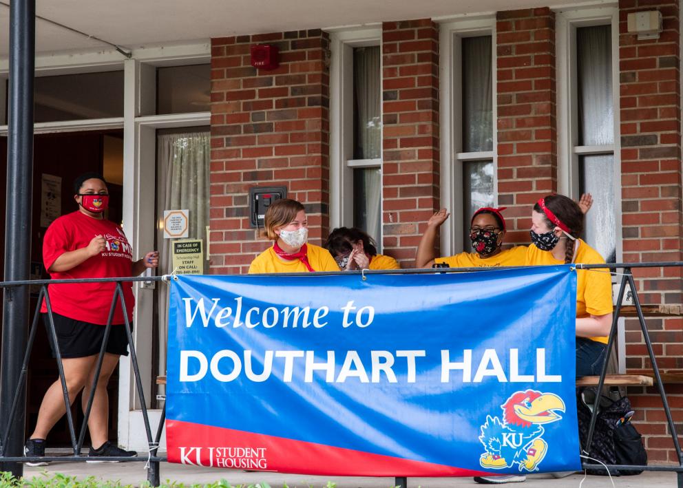 returning Douthart Hall residents smiling on the front porch, ready to help new residents move in