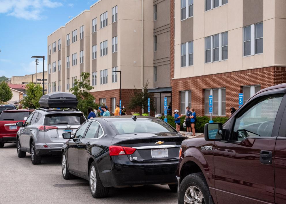 cars lined up to unload at Downs Hall on a bright move-in day