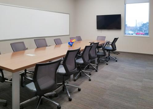 conference room with long table, white board, and TV