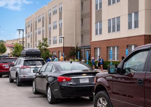 cars lined up to unload at Downs Hall on a bright move-in day