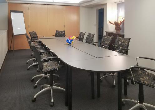 conference room with long table, chairs, and whiteboard
