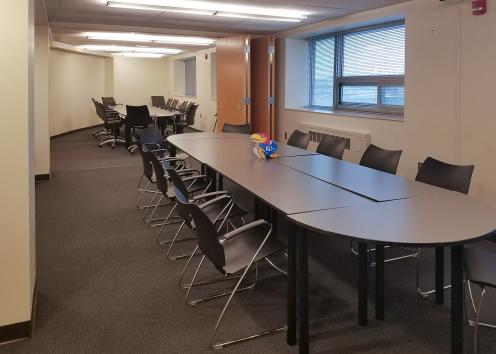 a long combined room with two conference tables and chairs, joined by an open accordion door