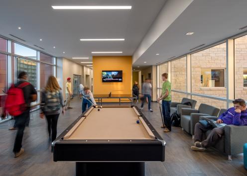 students playing pool, studying, and walking through inside the Daisy Hill Commons