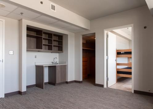 a newly renovated Templin Hall 4-person suite's living room with new carpeting, cabinets, and countertop area