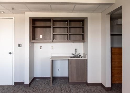 a newly renovated Templin Hall 4-person suite's living room with new carpeting, cabinets, and countertop area